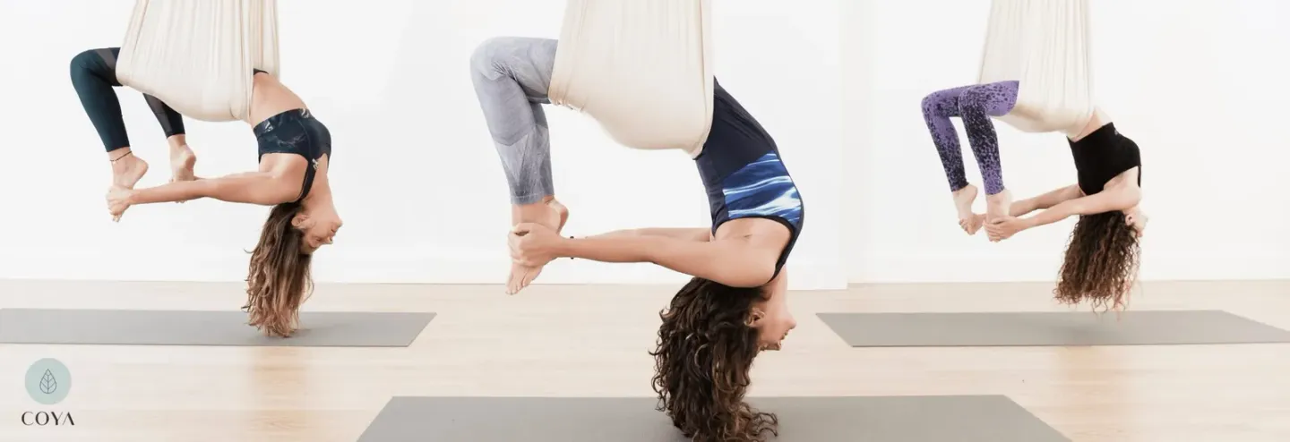 Τρεις γυναίκες ασκούν Aerial Yoga