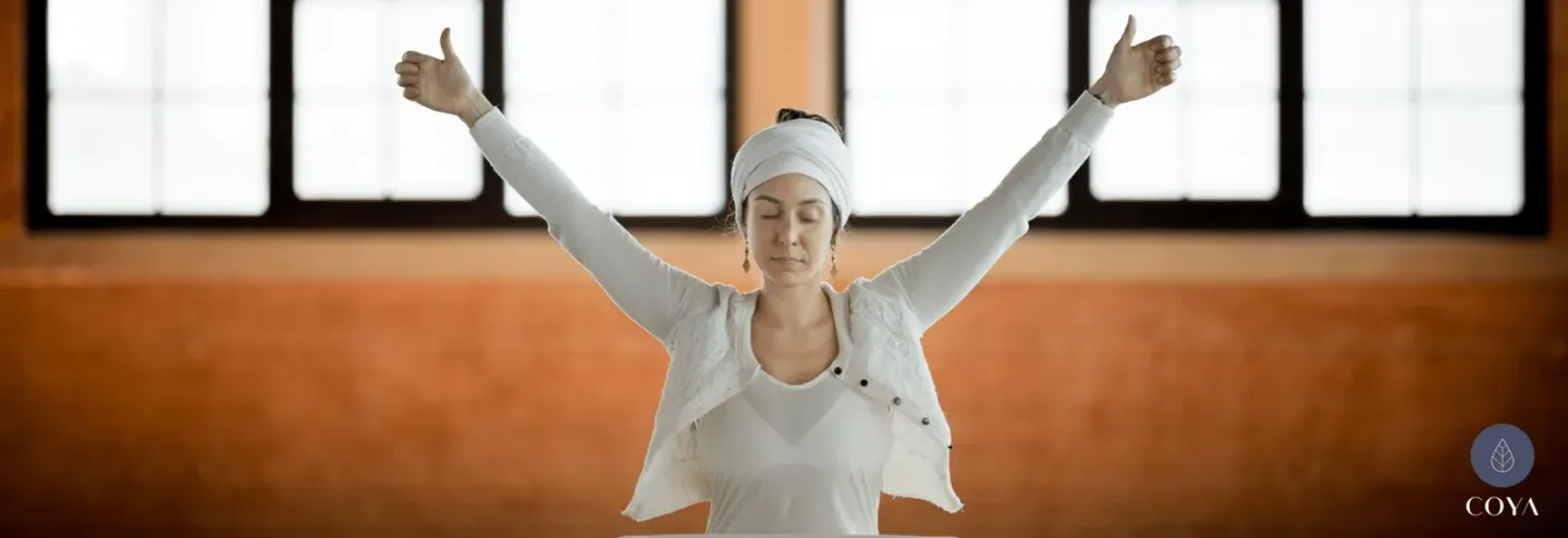 Μια γυναίκα με τα χέρια στον αέρα, για την kundalini yoga